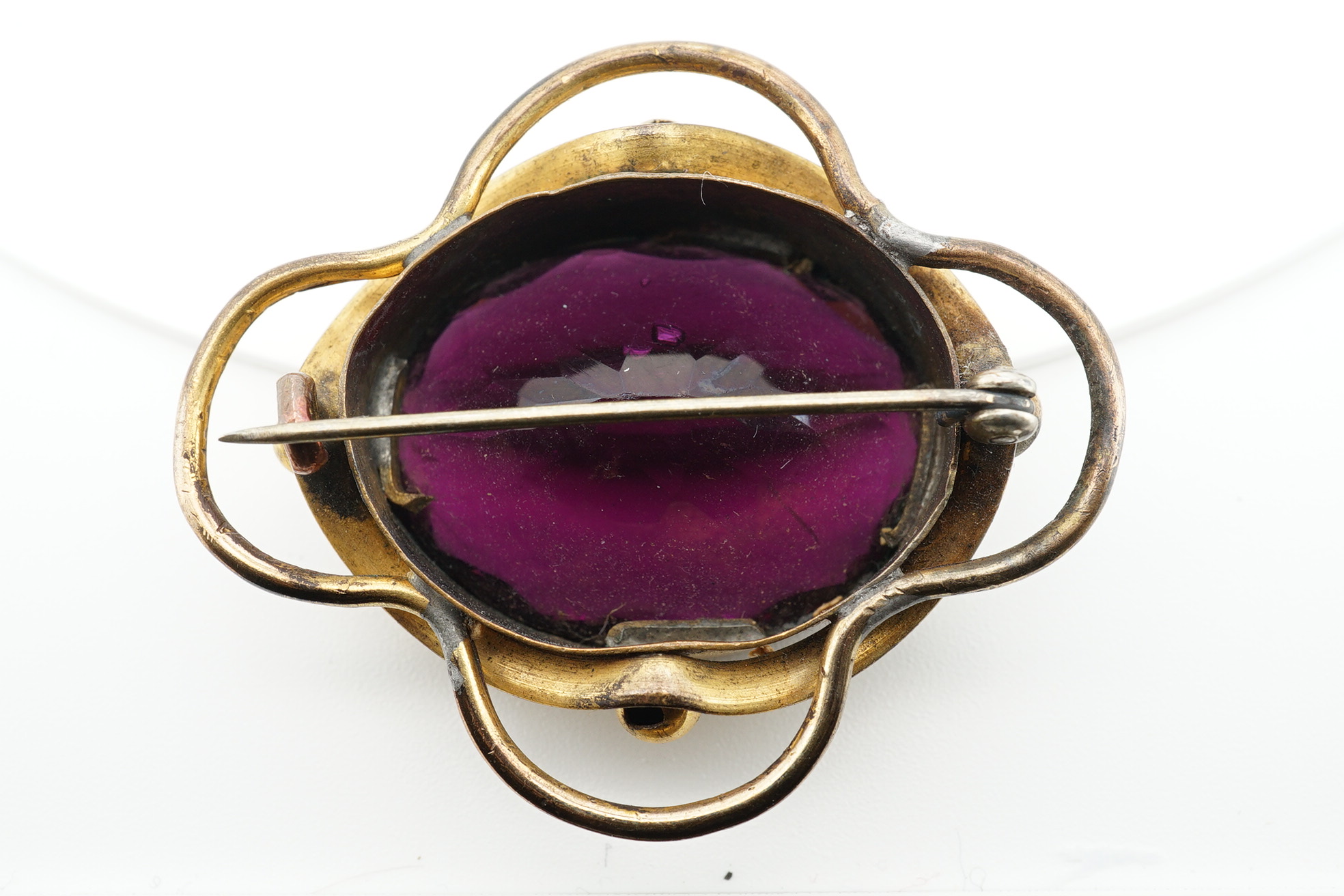 Two Victorian pinchbeck and amethyst paste set brooches, largest 62mm, together with three other items including a cameo shell brooch, tortoiseshell pique brooch and an agate mounted pill box. Condition - poor to fair